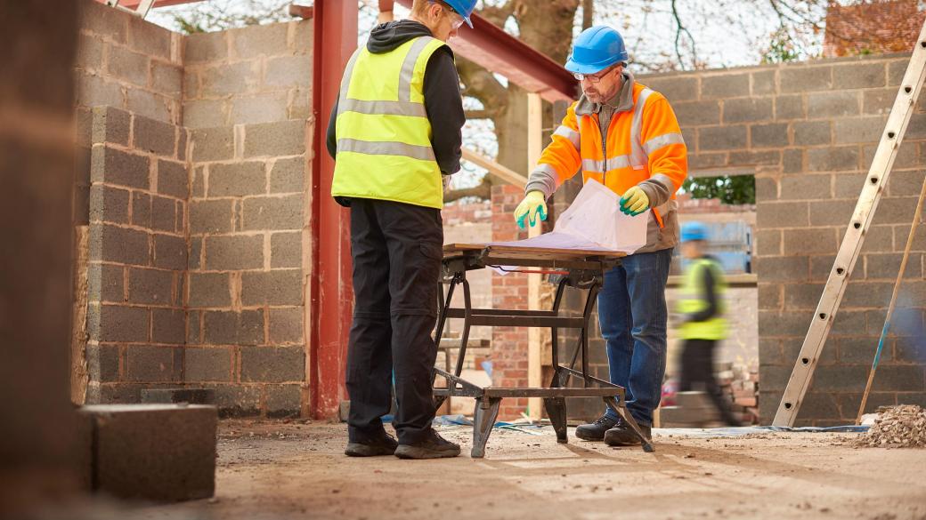 builders checking plans of home extension