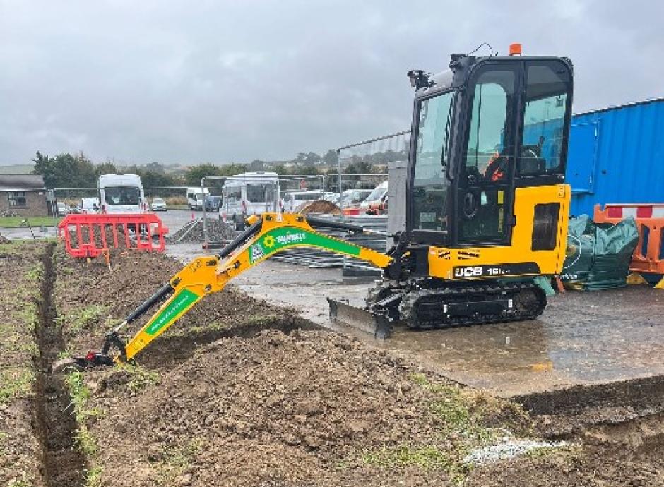 Digger digging trench for electric car charging cables